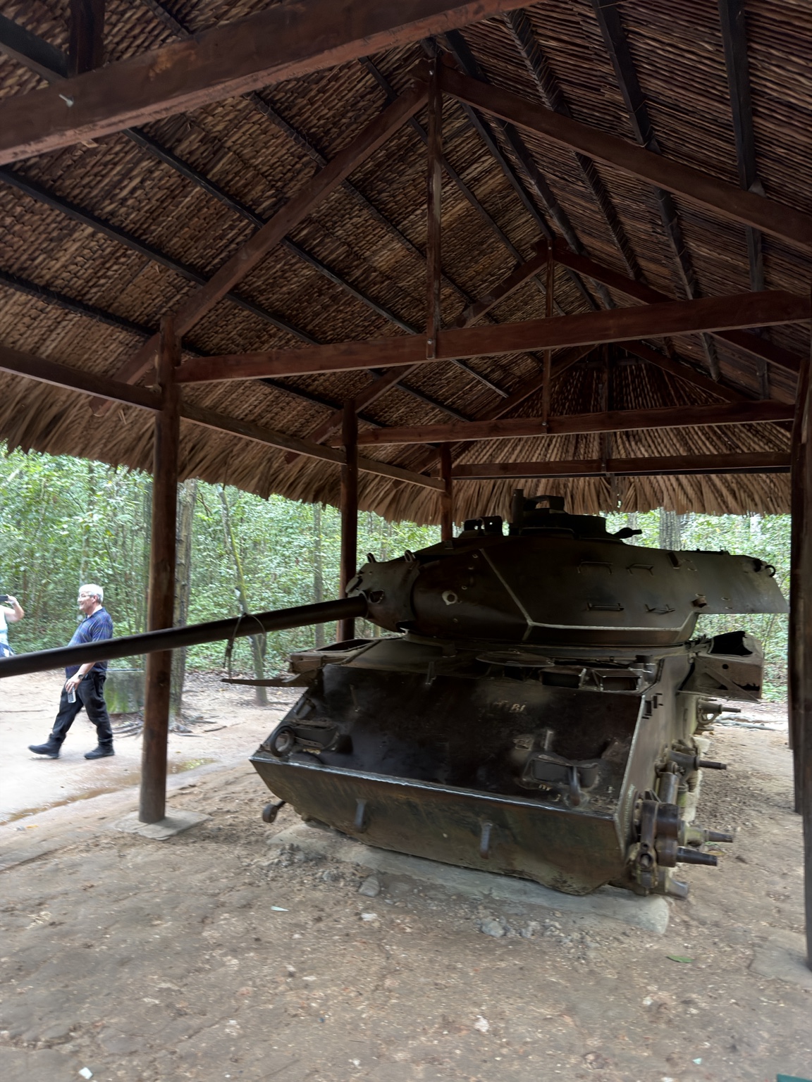A tank on display beneath a shelter during our Cu Chi visit